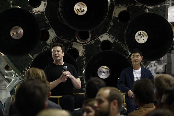 Elon Musk chief executive officer for Space Exploration Technologies Corp. left responds to a question as Yusaku...