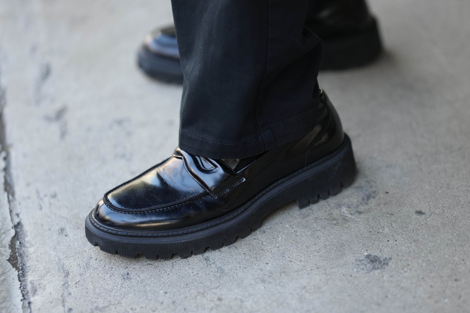 NEW YORK NEW YORK  FEBRUARY 11 A guest wears black suit pants a black nylon tote bag from Prada black shiny varnished...
