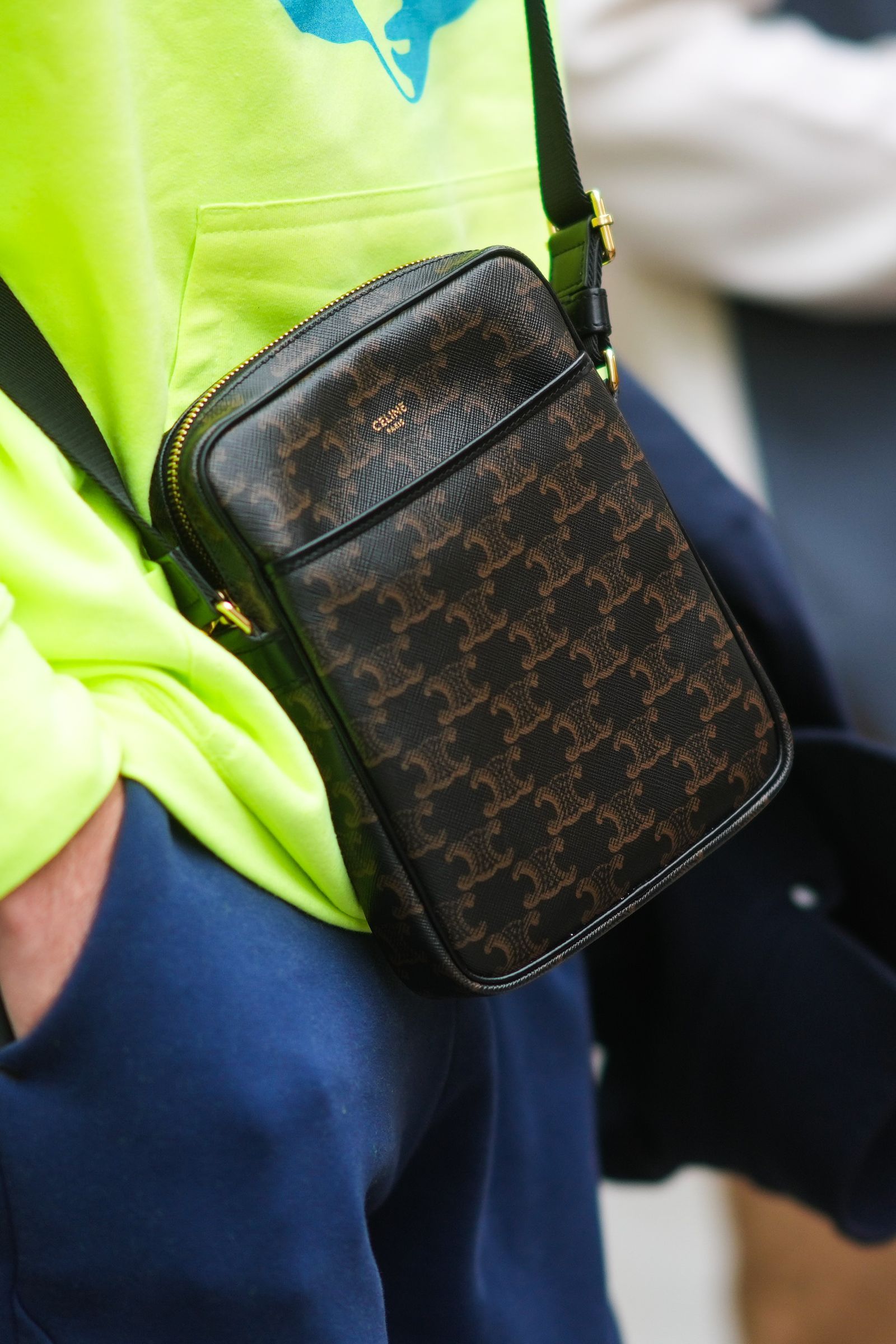 PARIS FRANCE  JUNE 23 A guest wears a neon yellow hoodie sweater with a pale blue printed face a black and brown CÃ©line...