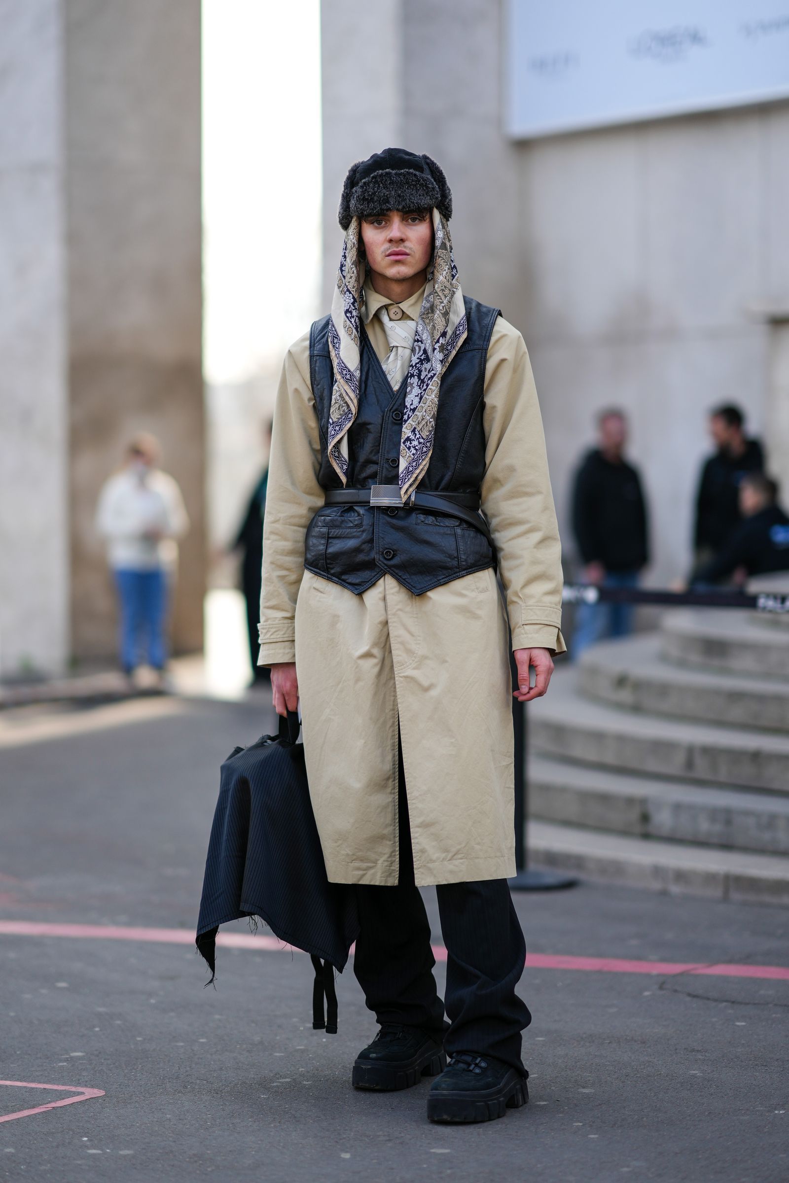 PARIS FRANCE  MARCH 05 A guest wears a gray fur hat a beige  brown  navy blue print pattern silk scarf a beige long coat...