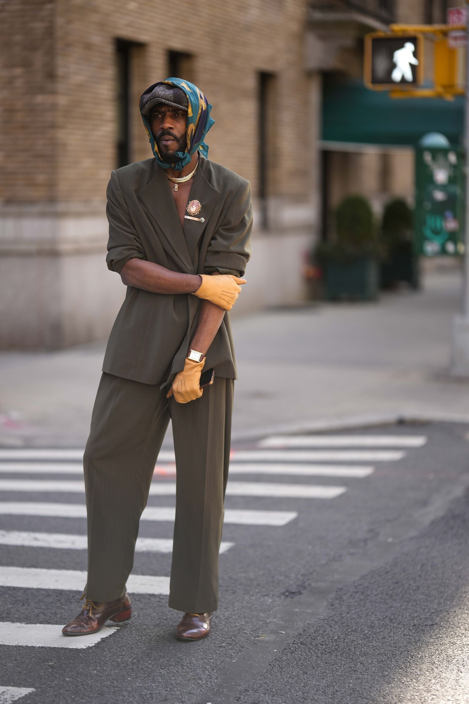 NEW YORK NEW YORK  FEBRUARY 13 A guest wears a brown and beige striped print pattern wool beret a green and yellow print...