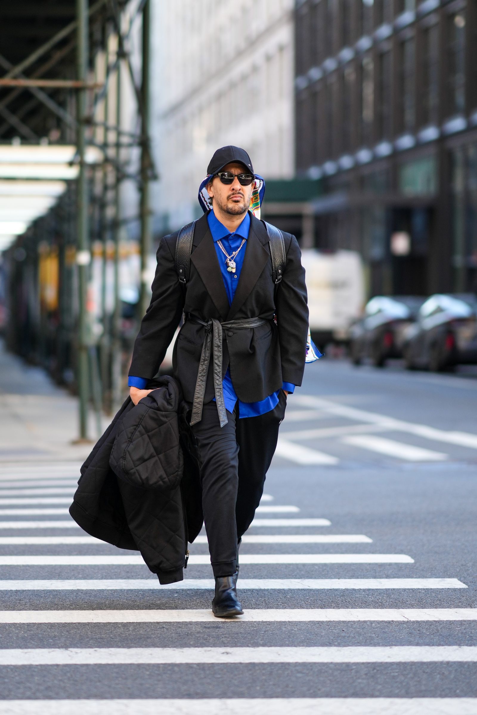 NEW YORK NEW YORK  FEBRUARY 11 A guest wears a black cap a navy blue  gold  green  red  white print pattern silk scarf...