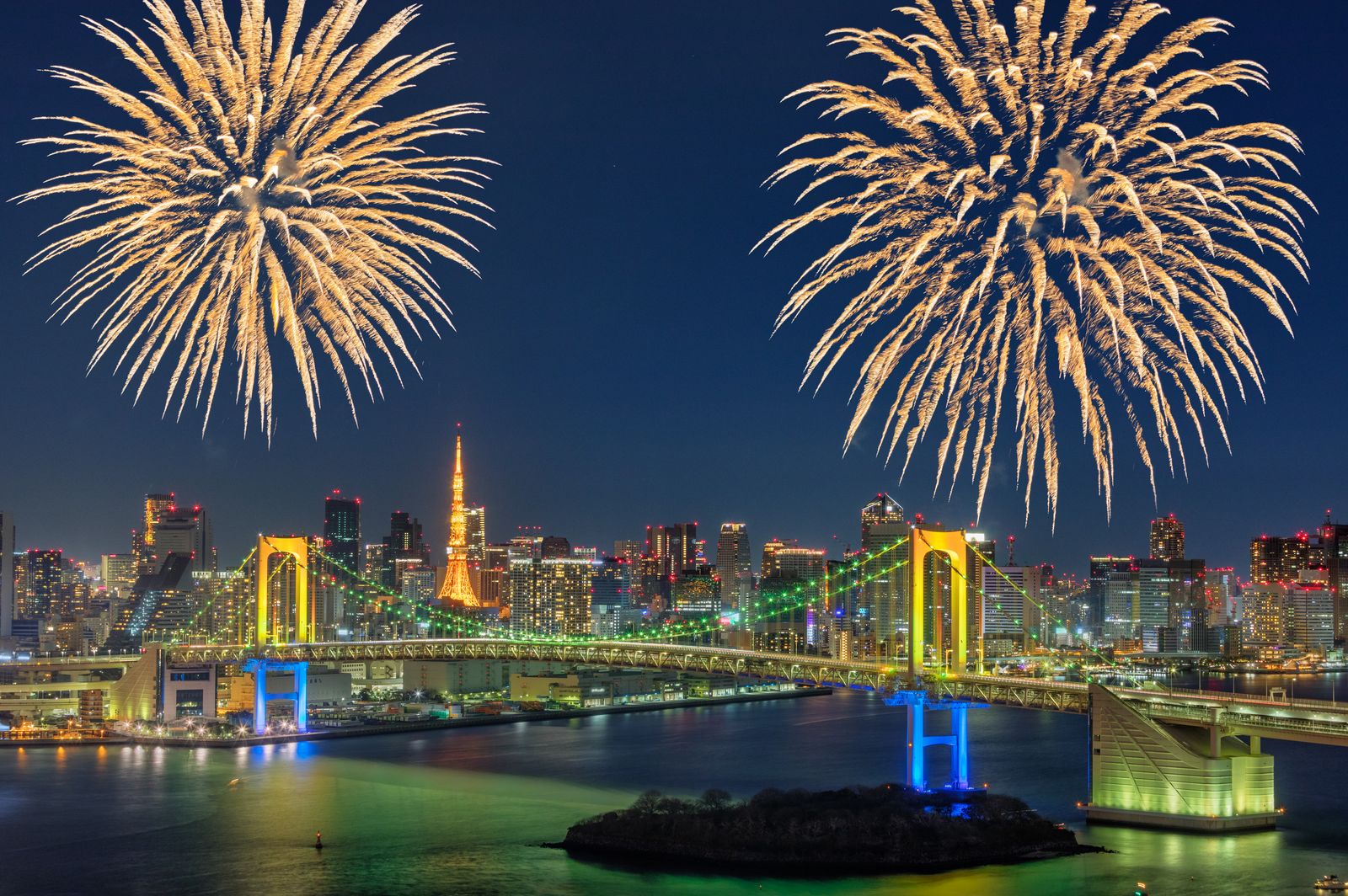 Colorful display of fireworks above  the Rainbow Bridge in Tokyo Japan. Waterfront in Shibaura  a district of Minato...